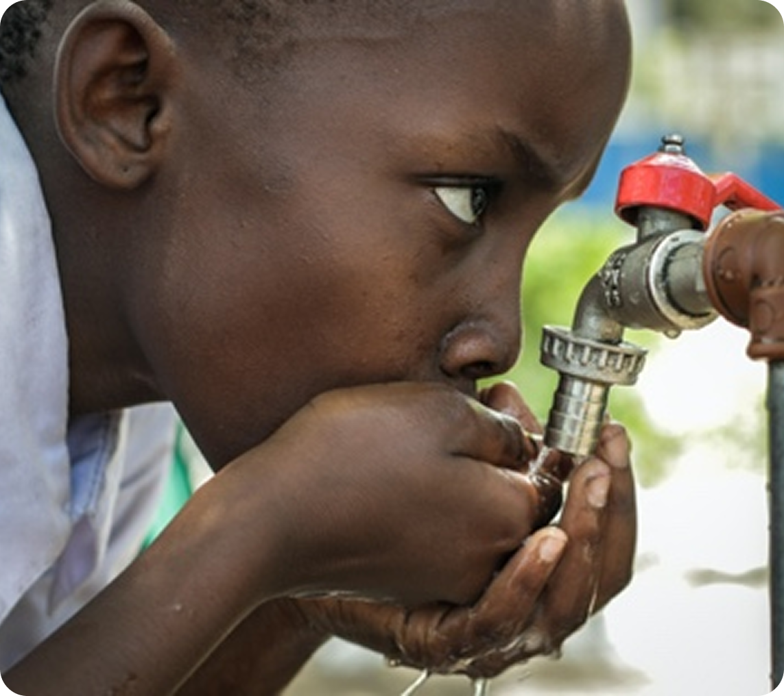 Child drinking water from outdoor tap.