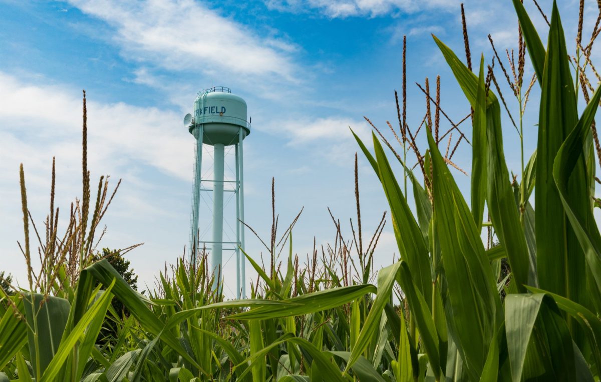 A water tower in the middle of a field.