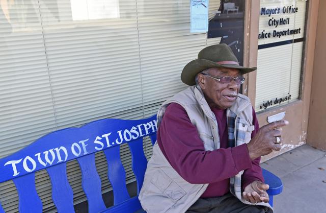 A man sitting on top of a bench.